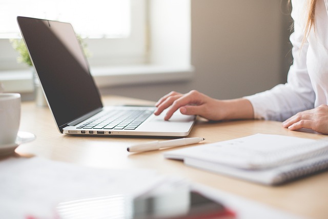 journalist researching technology sources with laptop and documents